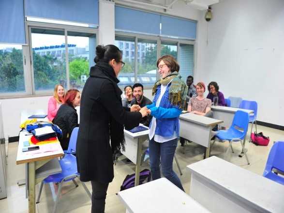 Ms. Fang yan is giving Souvenir cards to students